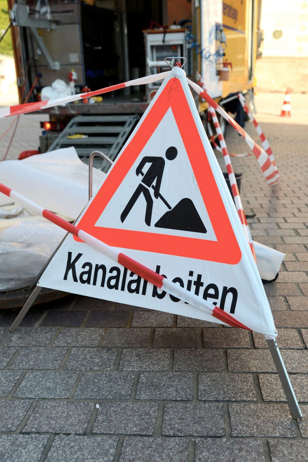 Aar-Einrich - Rohr- und Kanaltechnik - Ein Arbeiter inspiziert einen offenen Schacht mit einem Abwasserrohr.